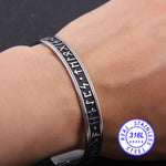 bracelet nordique gravure de runes argent sur fond noir - bracelet torque ouvert. Photo bracelet porté sur poignet d'homme