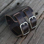 bracelet manchette viking en cuir ornée du symbole nordique du Mjolnir, le marteau de thor - photo sur fond bois - vue de l'arrière du bracelet