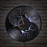 horloge murale viking avec Yggdrasil et forme yin yang sur mur beige clair, une partie du décors est couleur du mur car une partie du design est en évidé. L'horloge s'adaptera parfaitement à votre intérieur