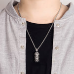 collier et pendentif japonais porte-bonheur en argent massif - photo bijou japonnais aux reflets argentés sur pull noir et veste grise